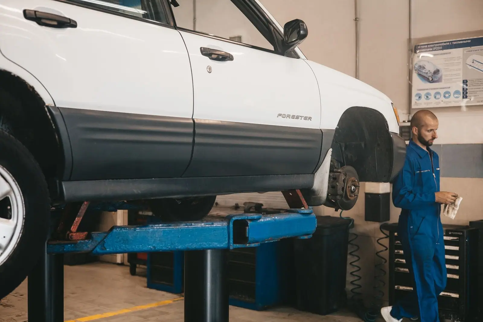 Mechanic assessing a car on a lift in the workshop