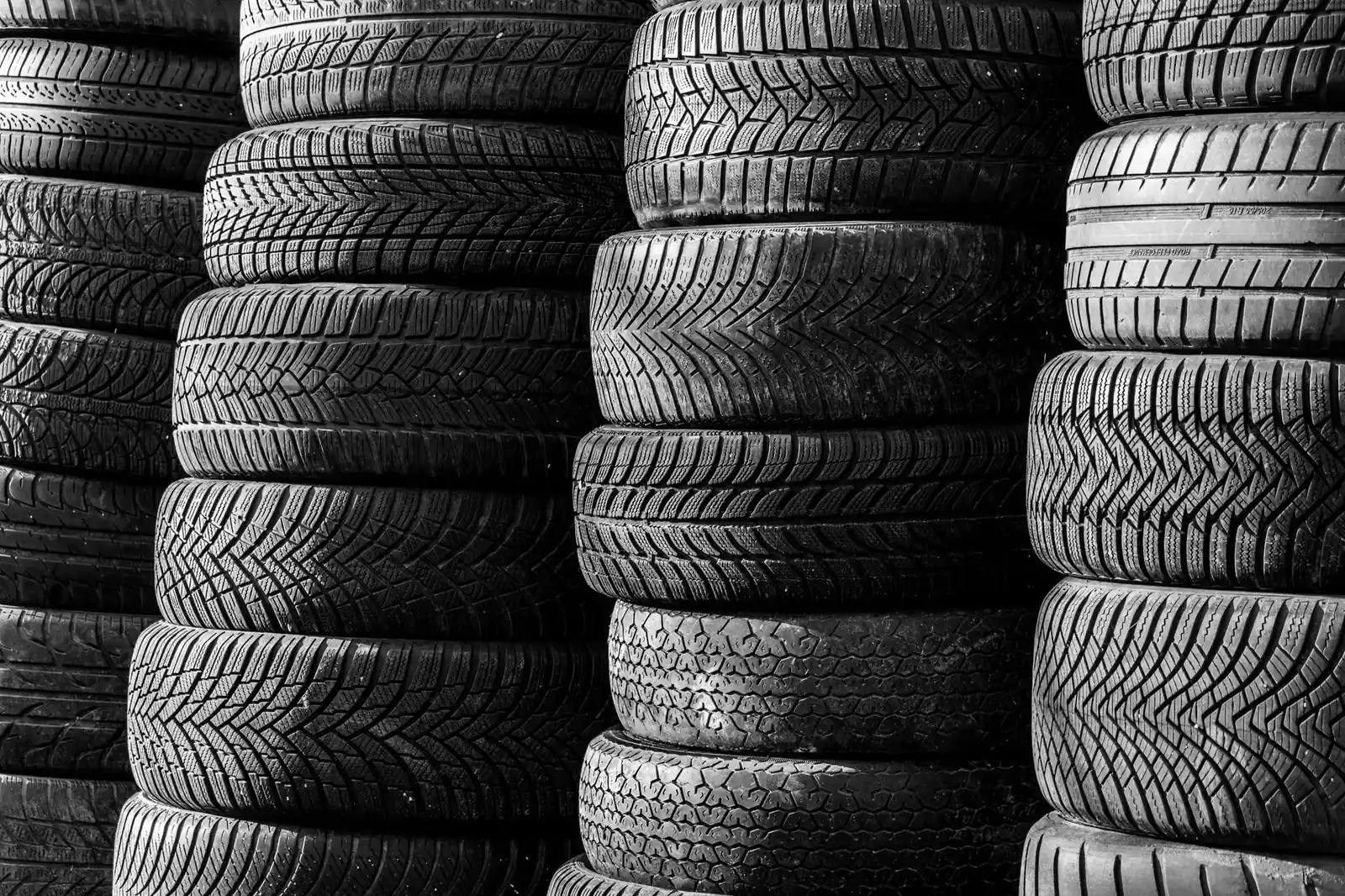 Black-and-white image of stacked tyres showing a range of tread patterns