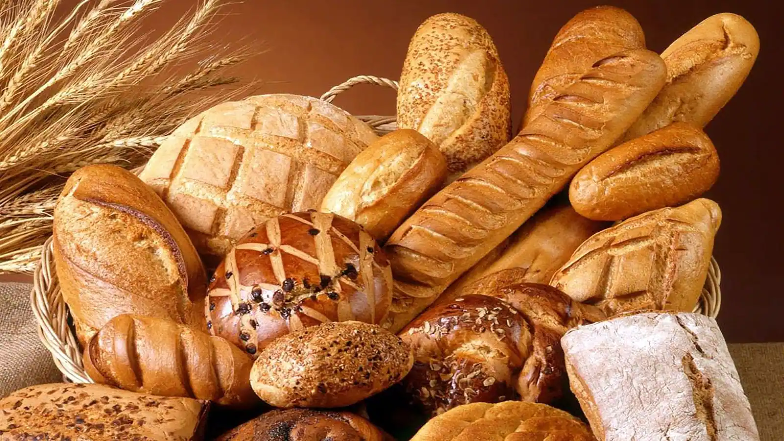 Bread, baguettes and rolls piled in a wicker basket.